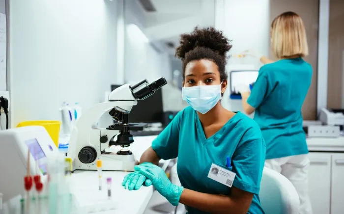 masked nurse at a lab workbench