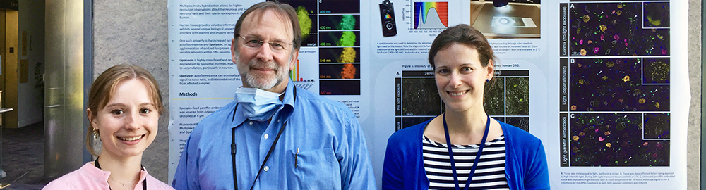 three researchers standing in front of a research poster