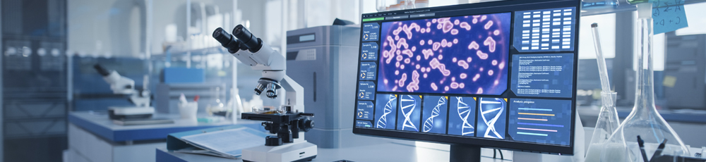 a lab with a miicroscope next to a computer screen showing dna strands