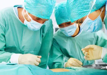 three surgeons operating on a patient